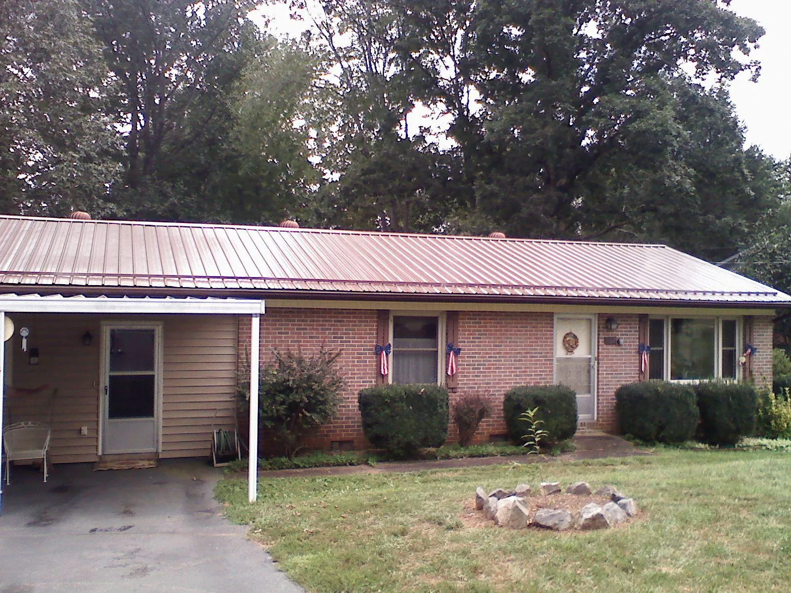Bronze metal roof and carport on a brick ranch home — Roof Repair work by our crew in Sinai